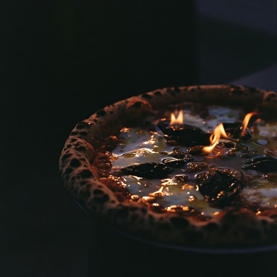 Napolitaanse pizza in donker licht met verse basilicum.