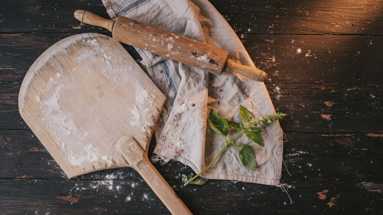 Tipo-00-bloem en bakkersgerei op een donker werkblad.
